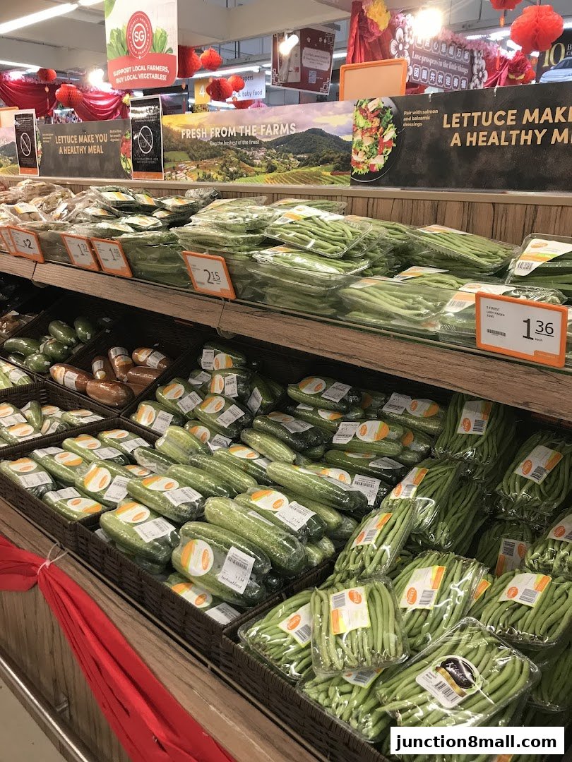 A display of fresh, packaged vegetables, including cucumbers and green beans, in a supermarket.