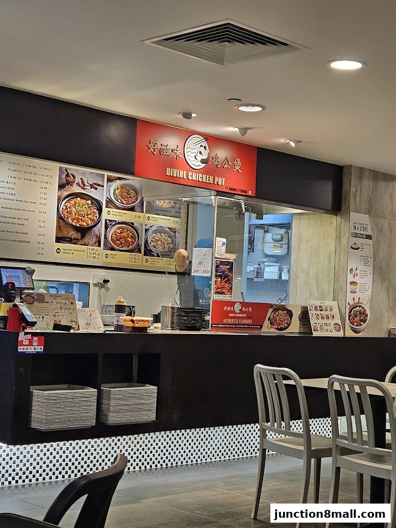 A food stall counter with a menu board, food pictures, and seating area.