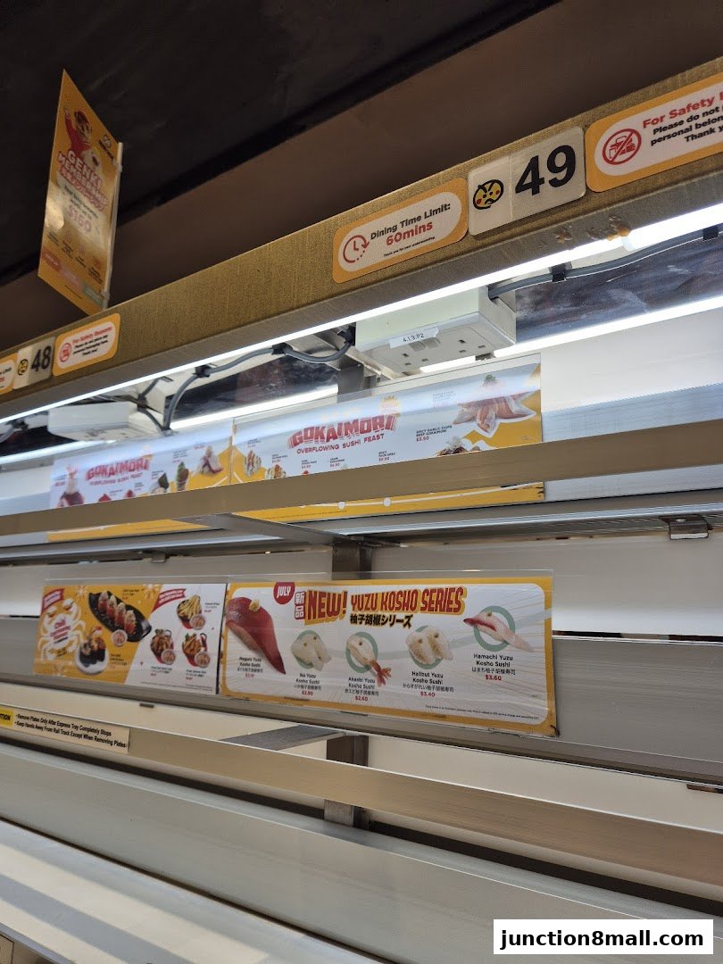 A conveyor belt sushi restaurant with various sushi dishes and promotional signs.