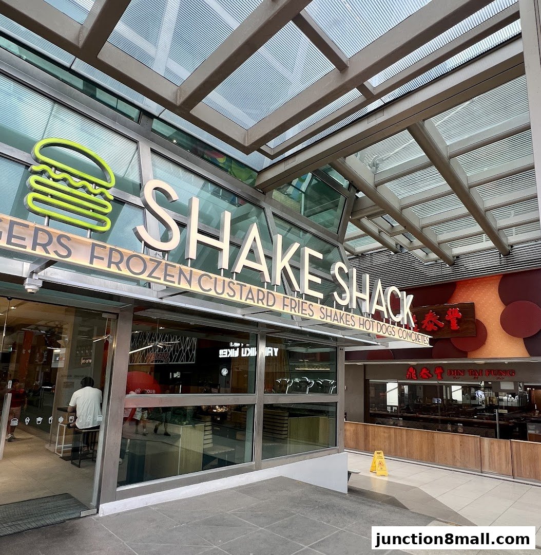 The exterior of a Shake Shack restaurant with its prominent signage and glass entrance.