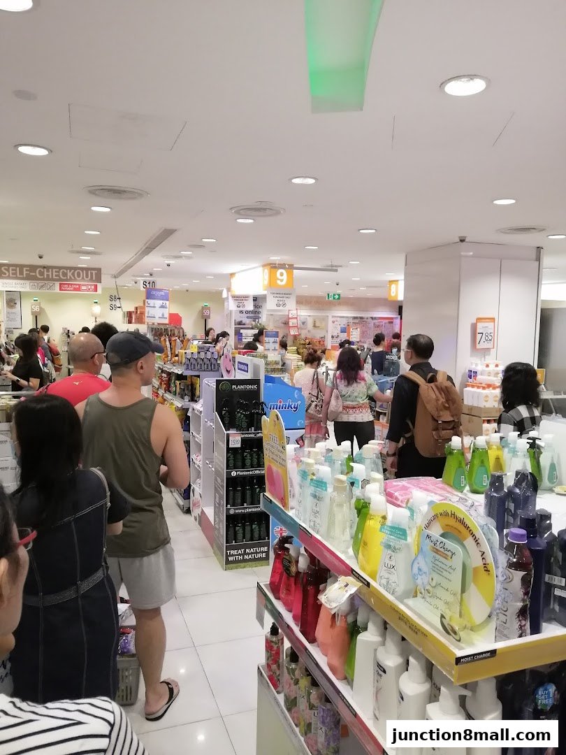 Customers shop for personal care products at FairPrice Finest, with self-checkout and various brands displayed.