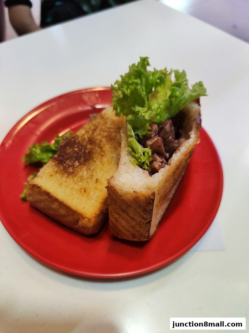 A close-up shot of a delicious sandwich with lettuce and meat filling on a red plate.