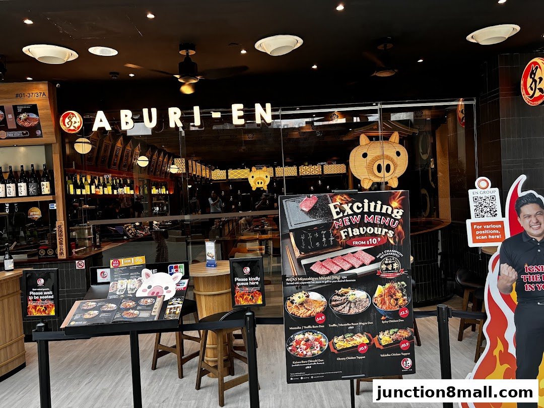 The entrance of Aburi-EN restaurant with a menu display and a cutout of a person.