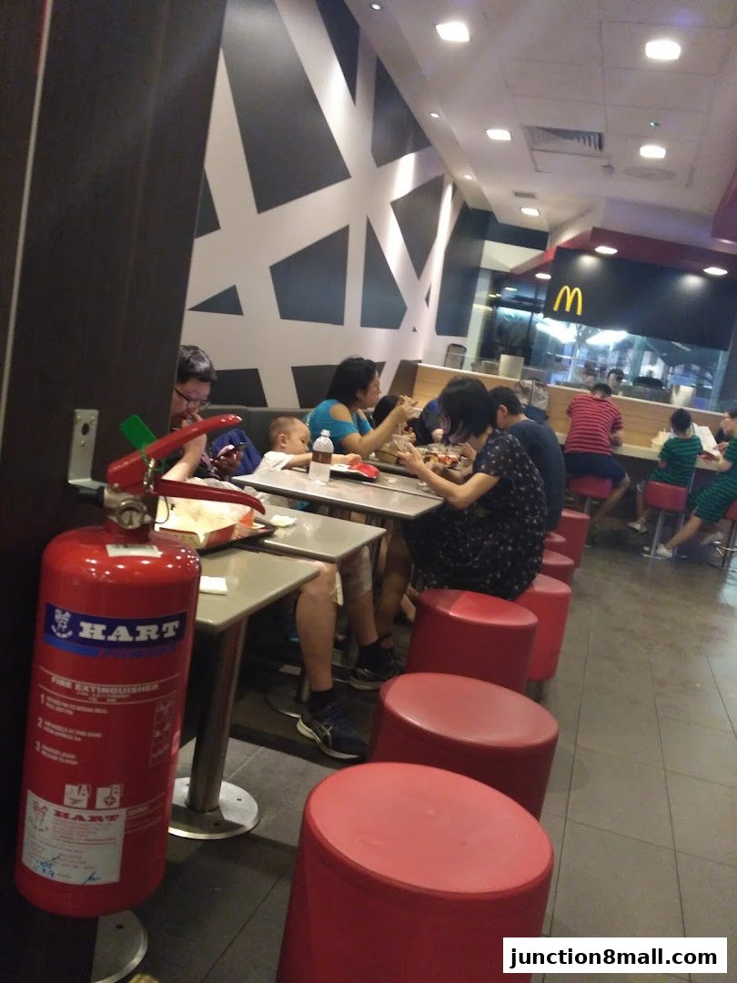 People dining at McDonald's with a fire extinguisher in the foreground.