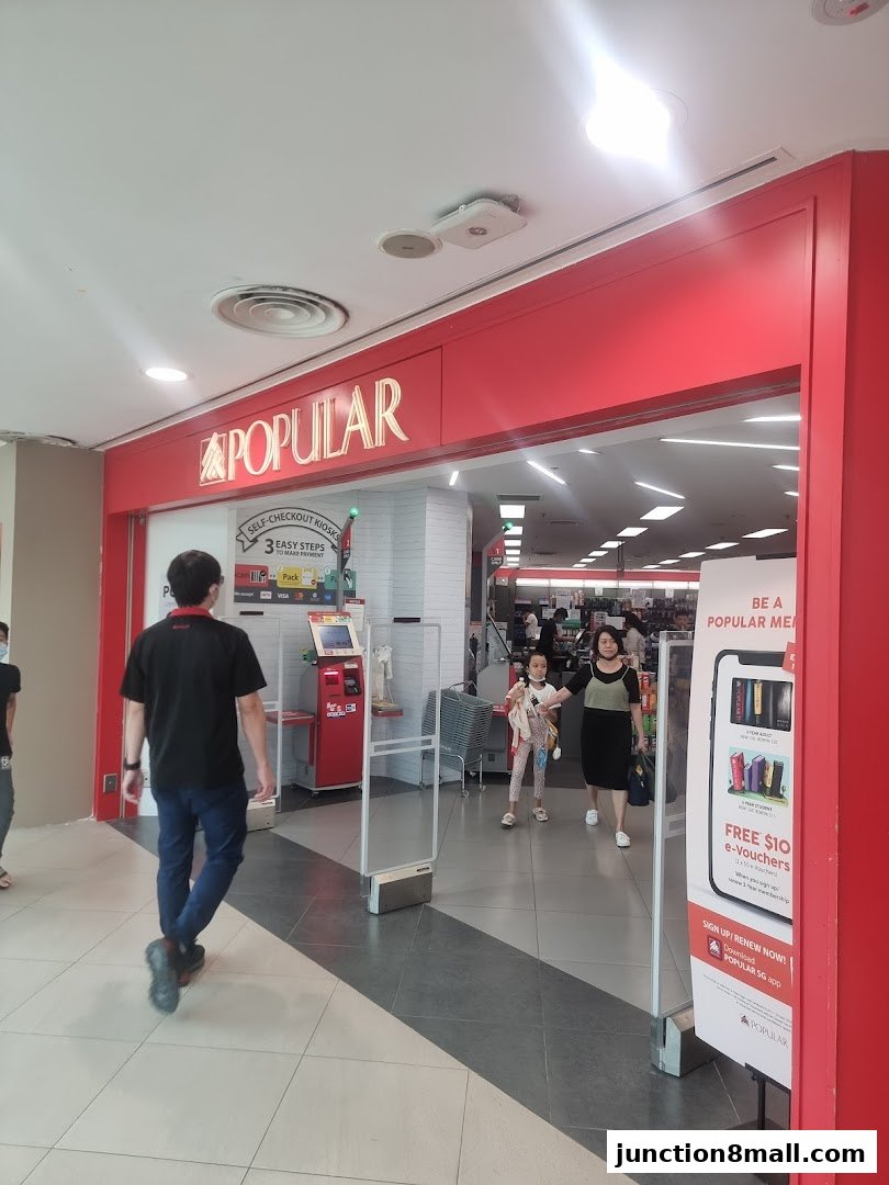 The entrance to a POPULAR bookstore with a red facade and signage.