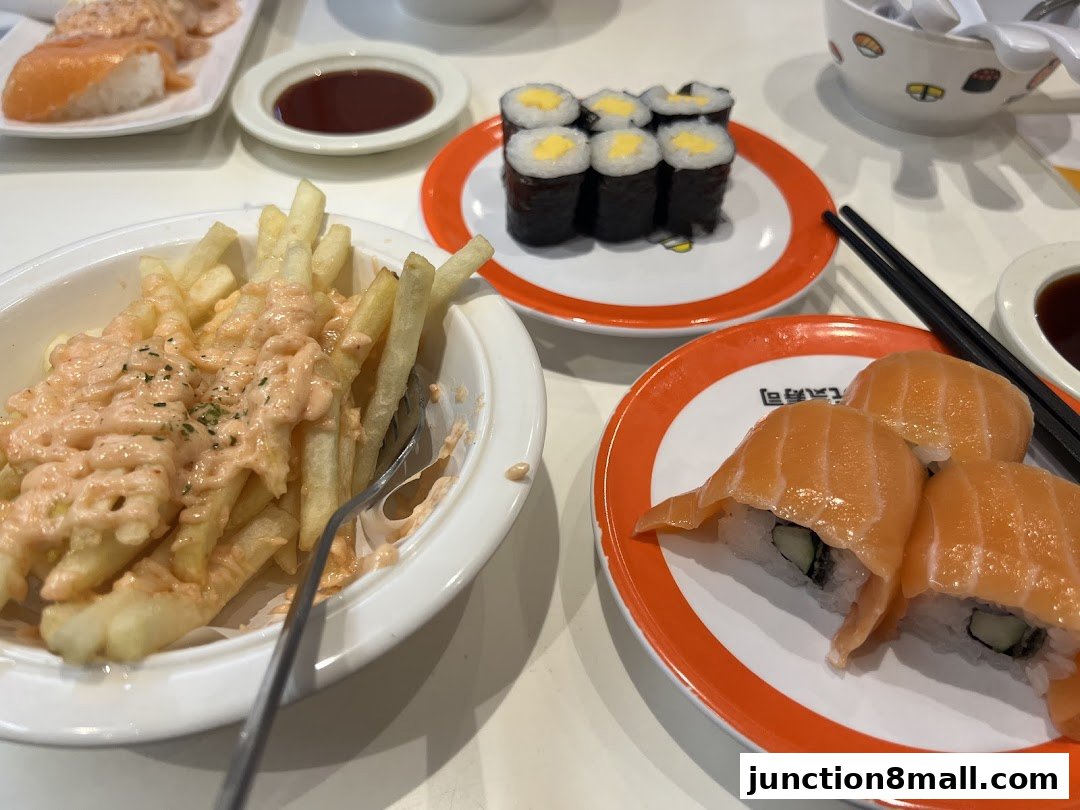A close-up of various sushi dishes and fries served at a restaurant.