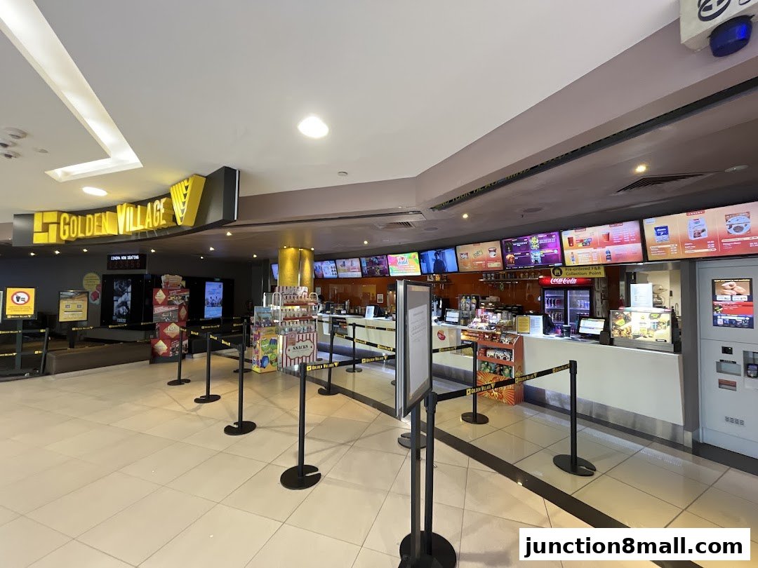 The interior of a Golden Village cinema lobby with a concession stand and movie posters.