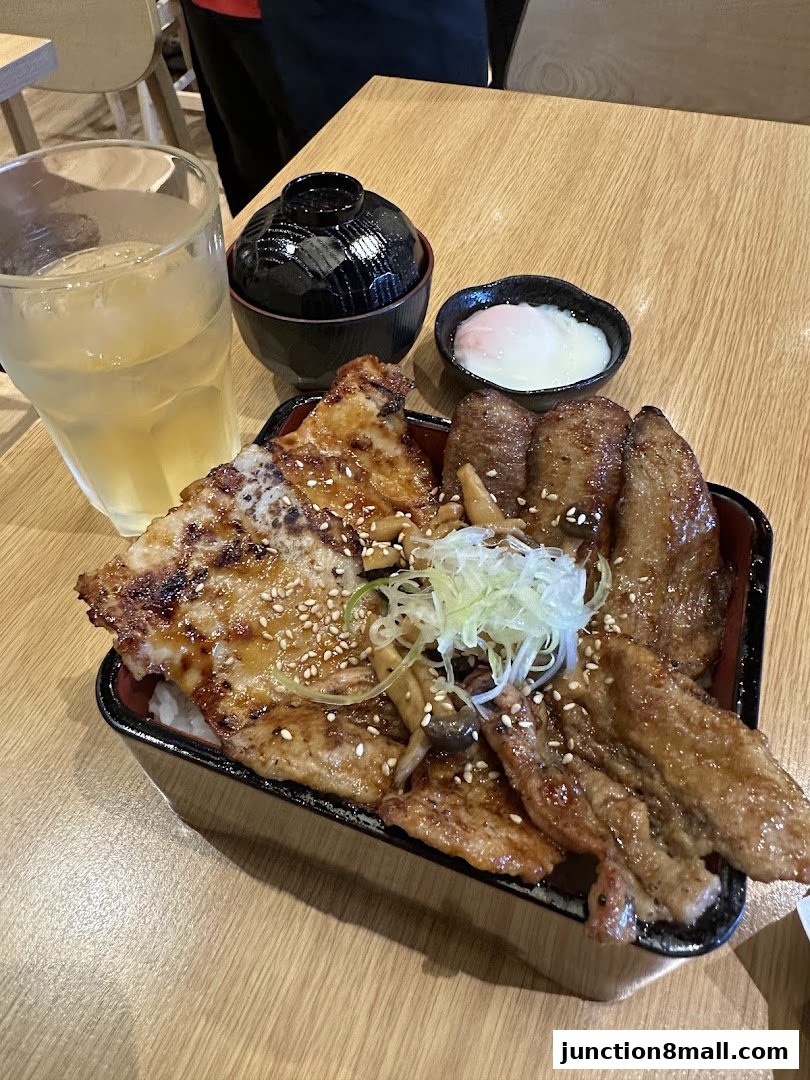A delicious Japanese rice bowl dish with grilled meat, a side of soup, and a soft-boiled egg.