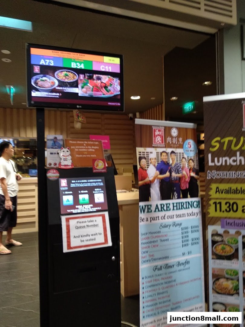 A queue management system and hiring poster at Watami Japanese Dining.