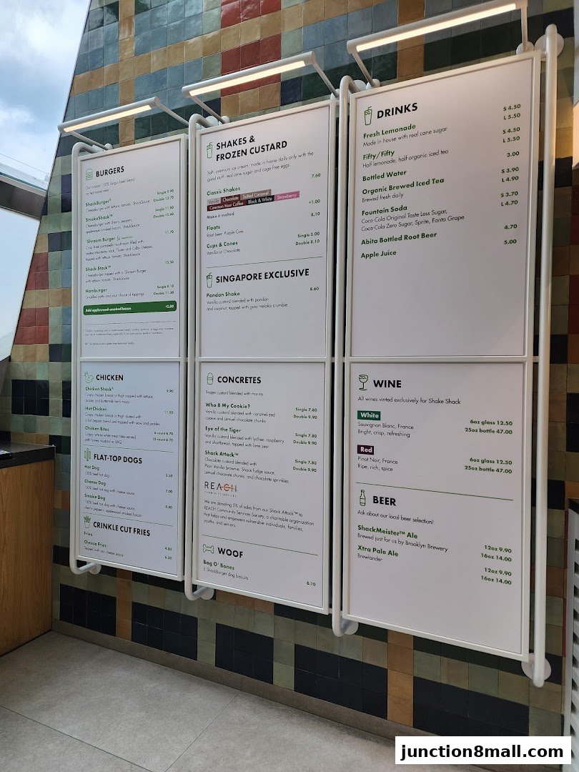 A menu board displaying various food and drink options from Shake Shack Junction 8.