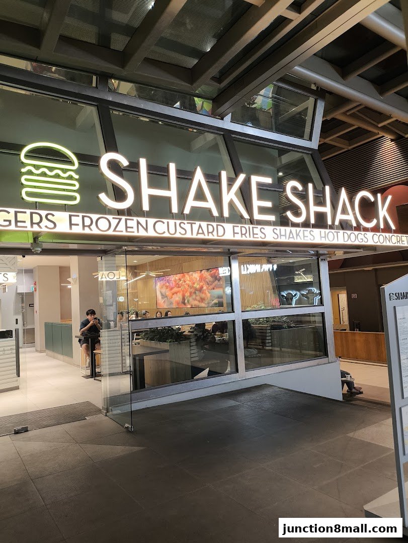 The exterior of a Shake Shack restaurant with its prominent signage and glass windows.