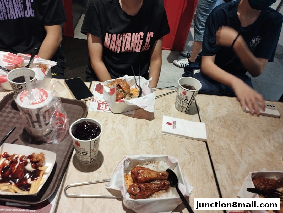 People enjoying crispy chicken meals and drinks at a table.