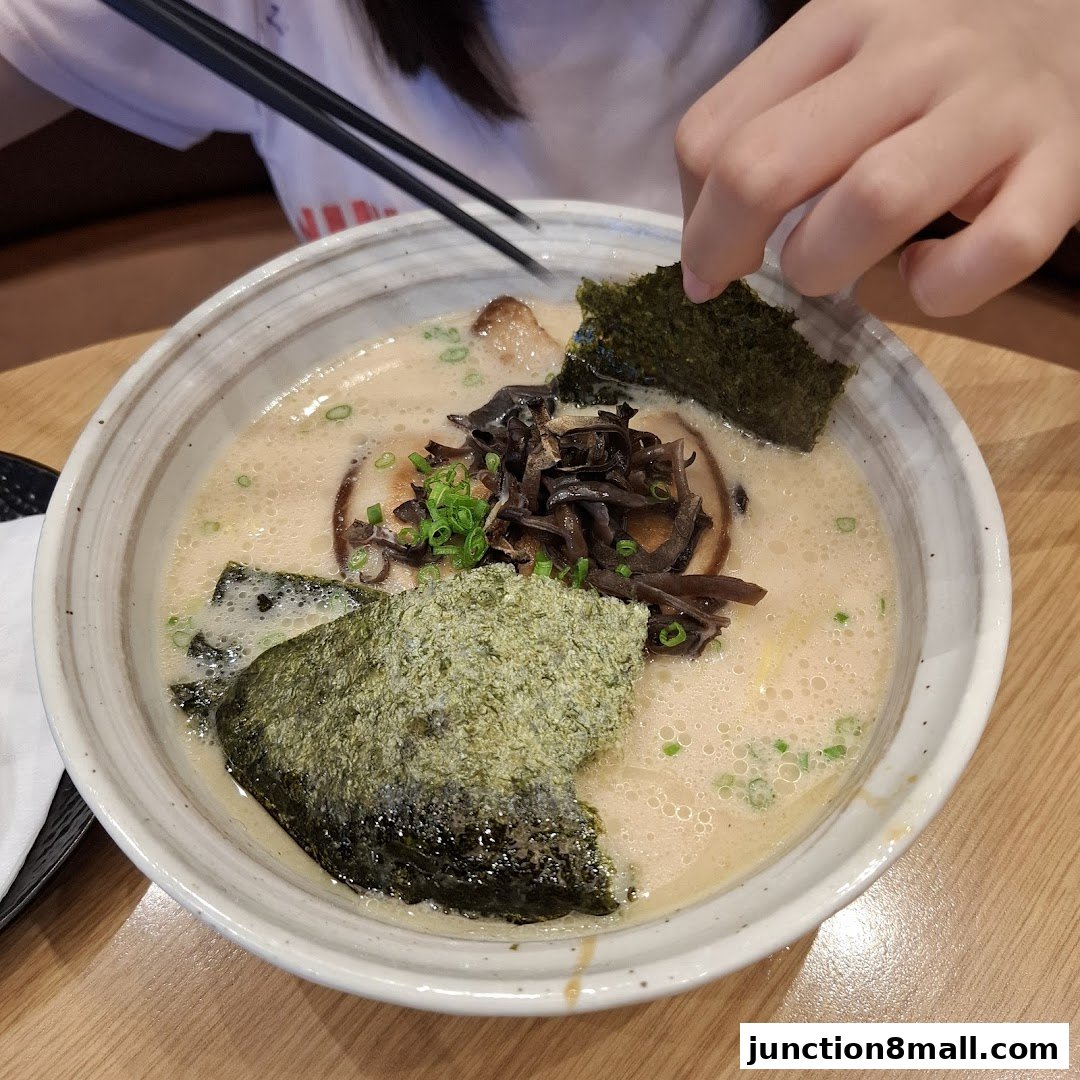 A close-up of a delicious bowl of ramen with nori, mushrooms, and chashu.