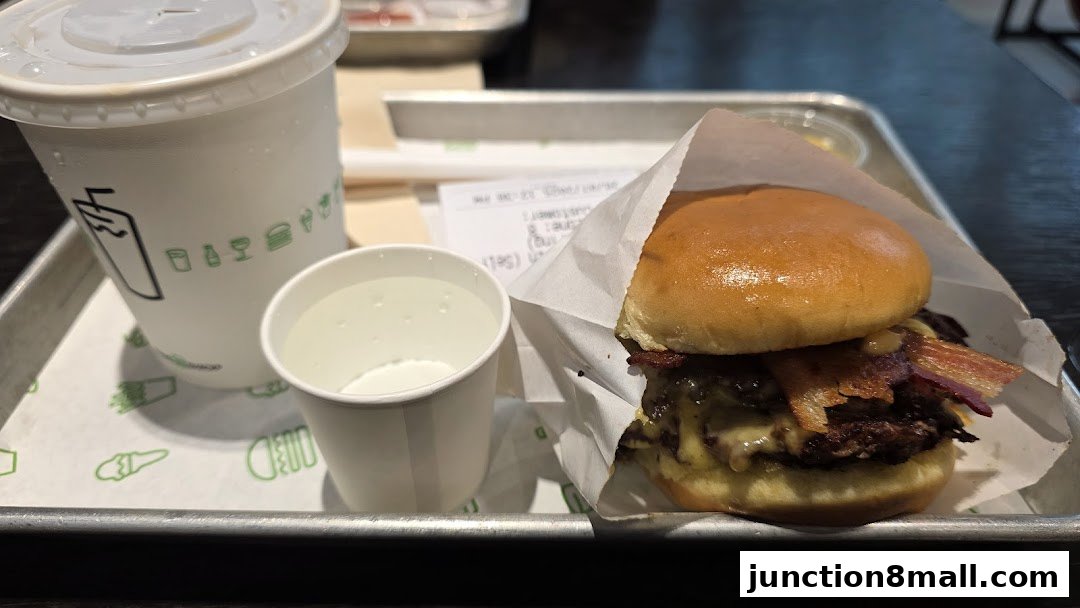 A close-up of a Shake Shack burger and drink on a tray with a receipt.