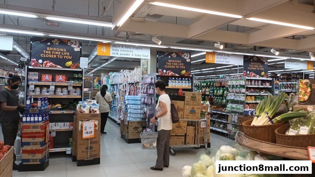 Interior view of a FairPrice Finest supermarket with aisles stocked with groceries and shoppers.