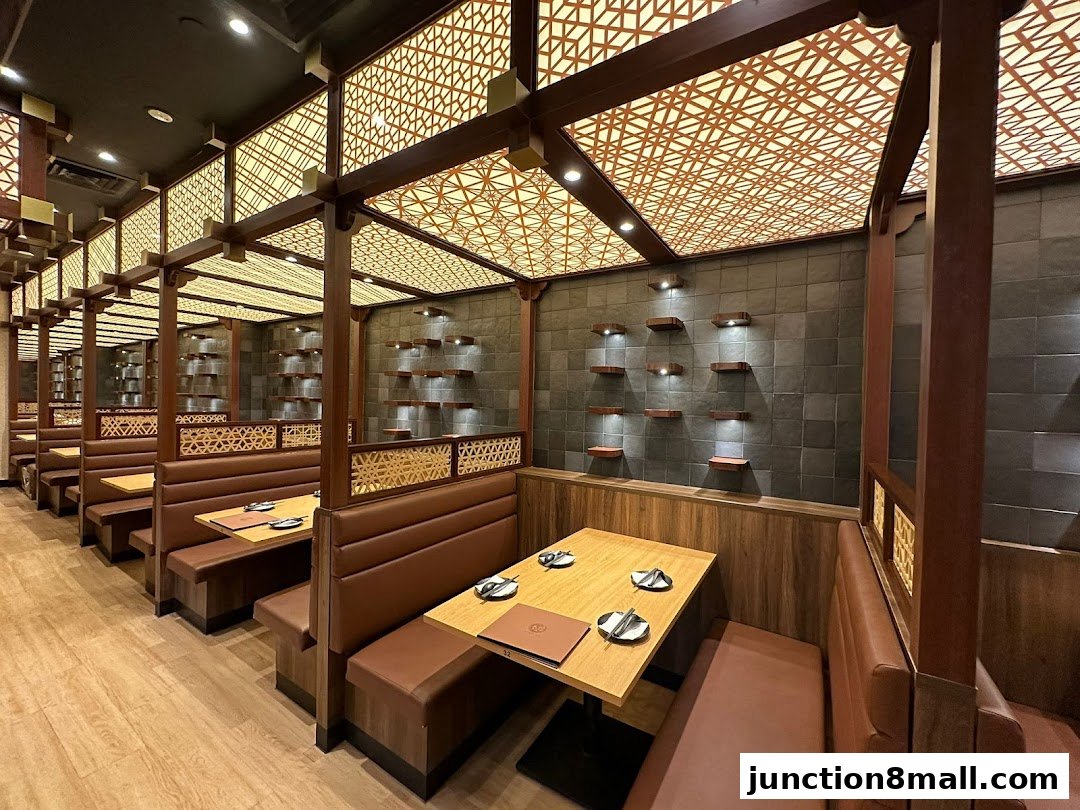 Interior view of a restaurant with booth seating and decorative ceiling panels.