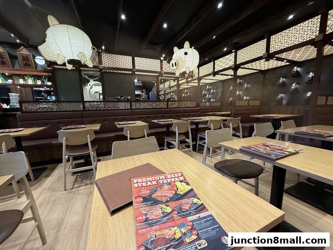 Interior of a Japanese restaurant with tables, chairs, and pig-shaped lanterns.