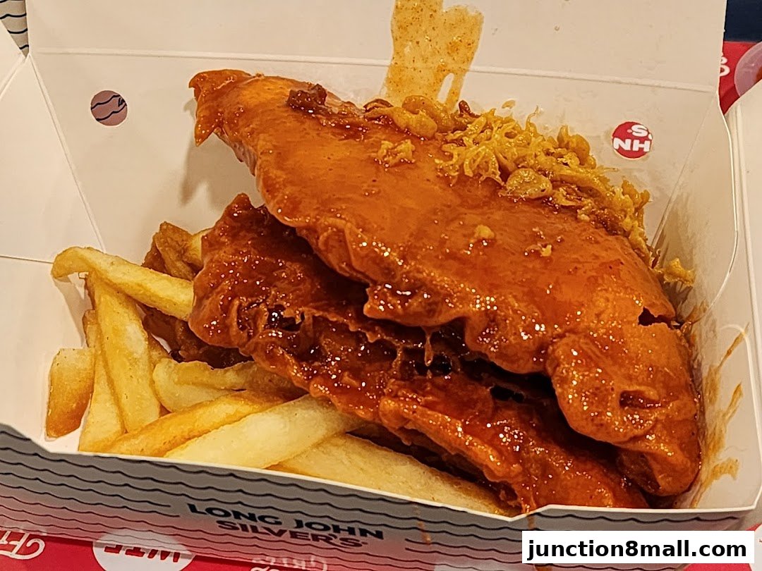 A box of Long John Silver's fish and chips, coated in a glossy sauce.
