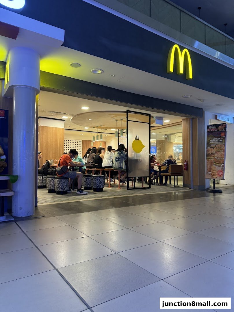 McDonald's restaurant interior with customers dining and the iconic golden arches visible.