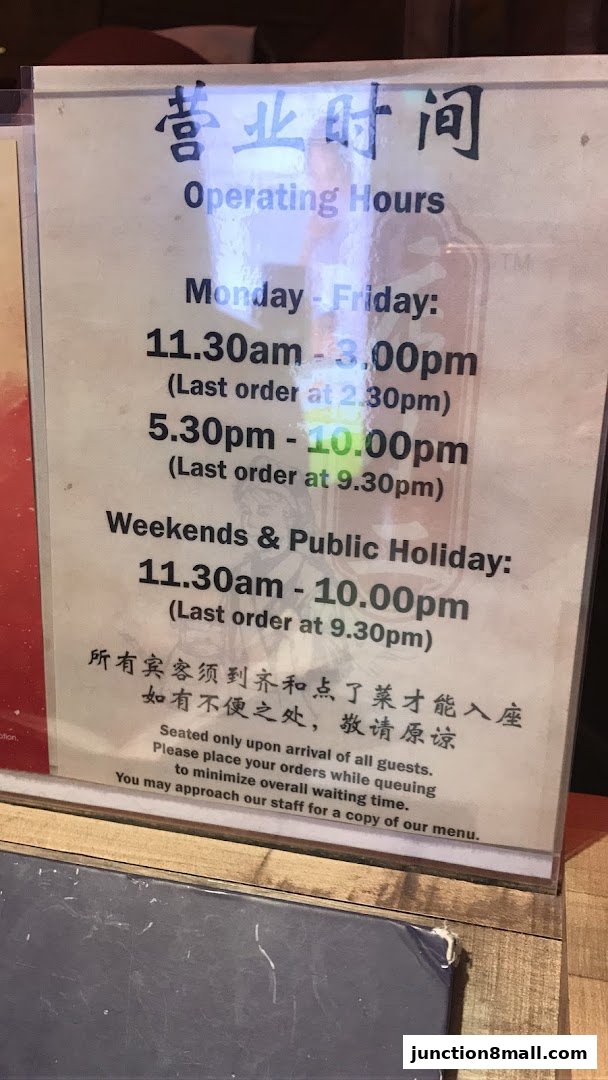 A sign displaying operating hours and seating policy for Dian Xiao Er Junction 8.