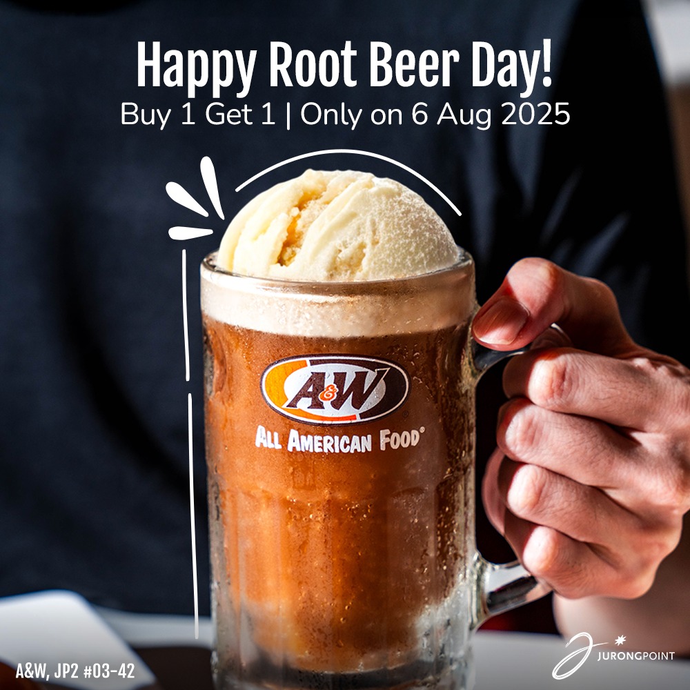 A frosty mug of root beer with a frothy head, perhaps with ice.