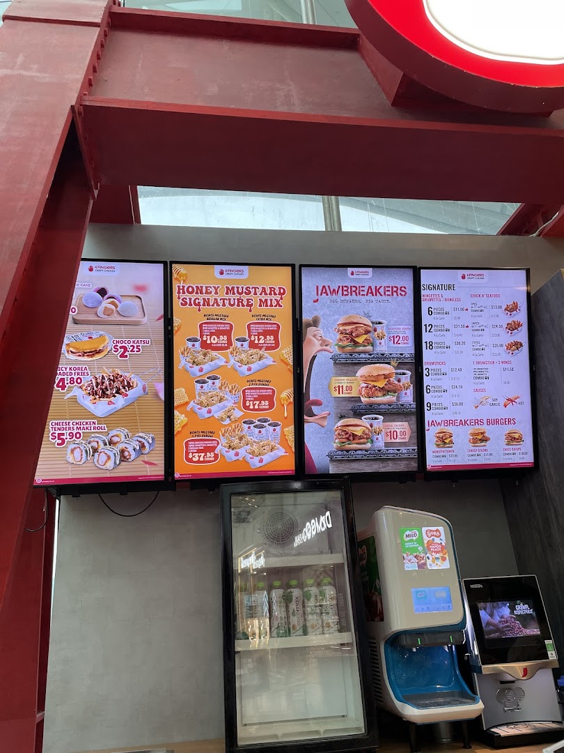 Multiple digital menu boards display food items, prices, and promotions at 4Fingers Crispy Chicken.