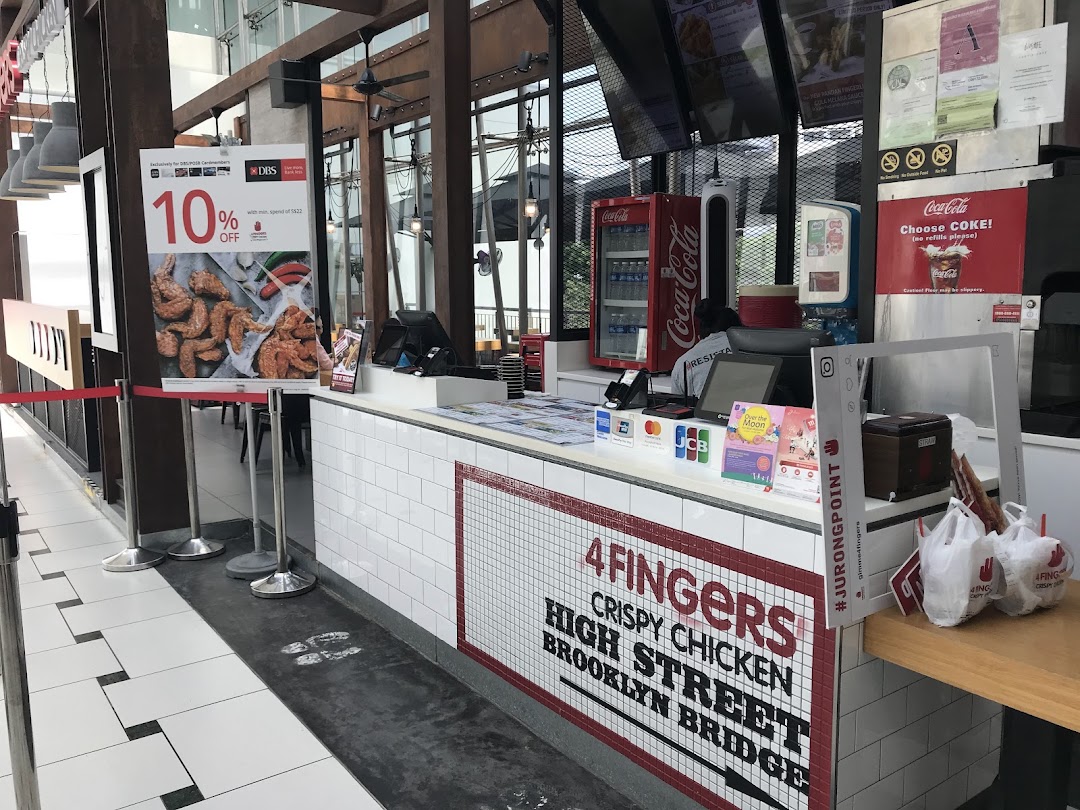 The 4Fingers Crispy Chicken counter with branding, a Coca-Cola fridge, and a promotional offer poster.