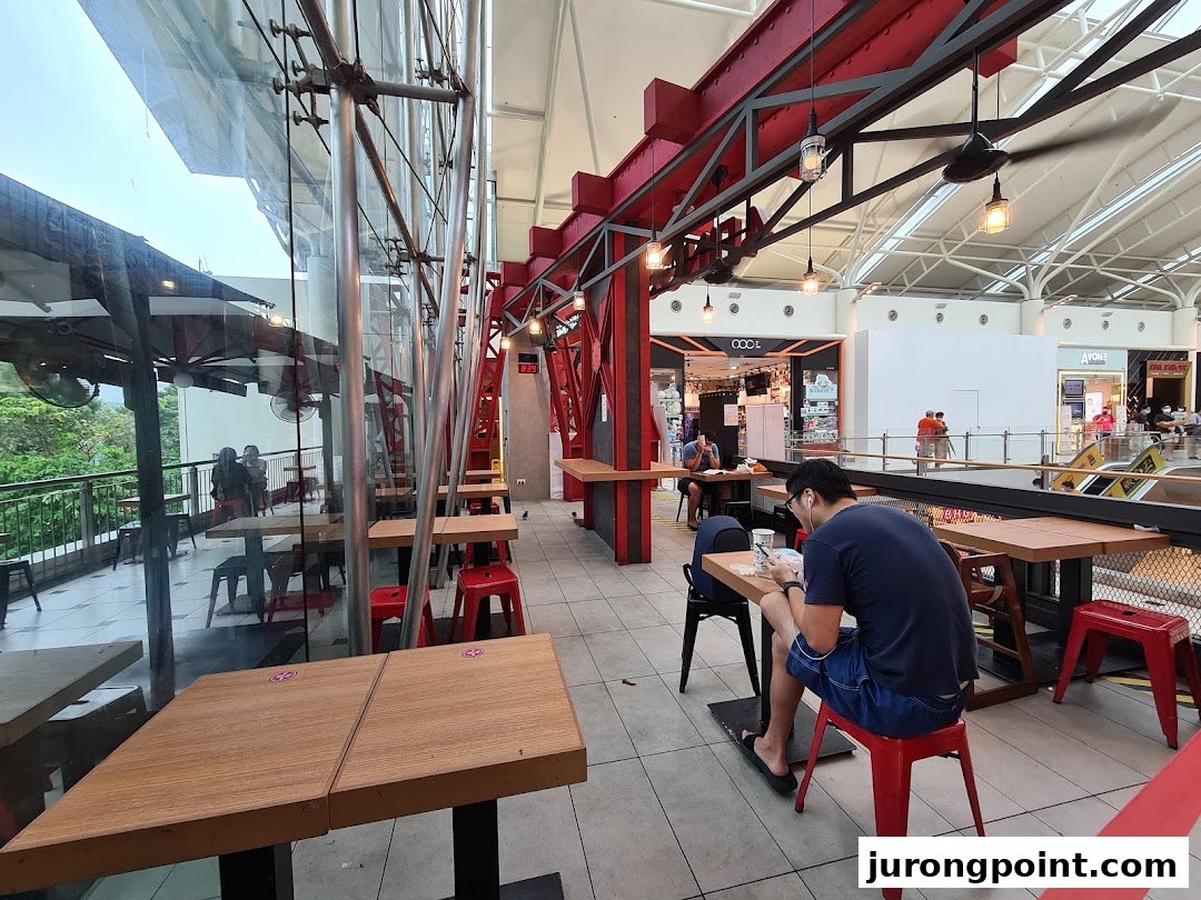 Diners enjoy a spacious, modern seating area with mall and outdoor views at 4Fingers Crispy Chicken.