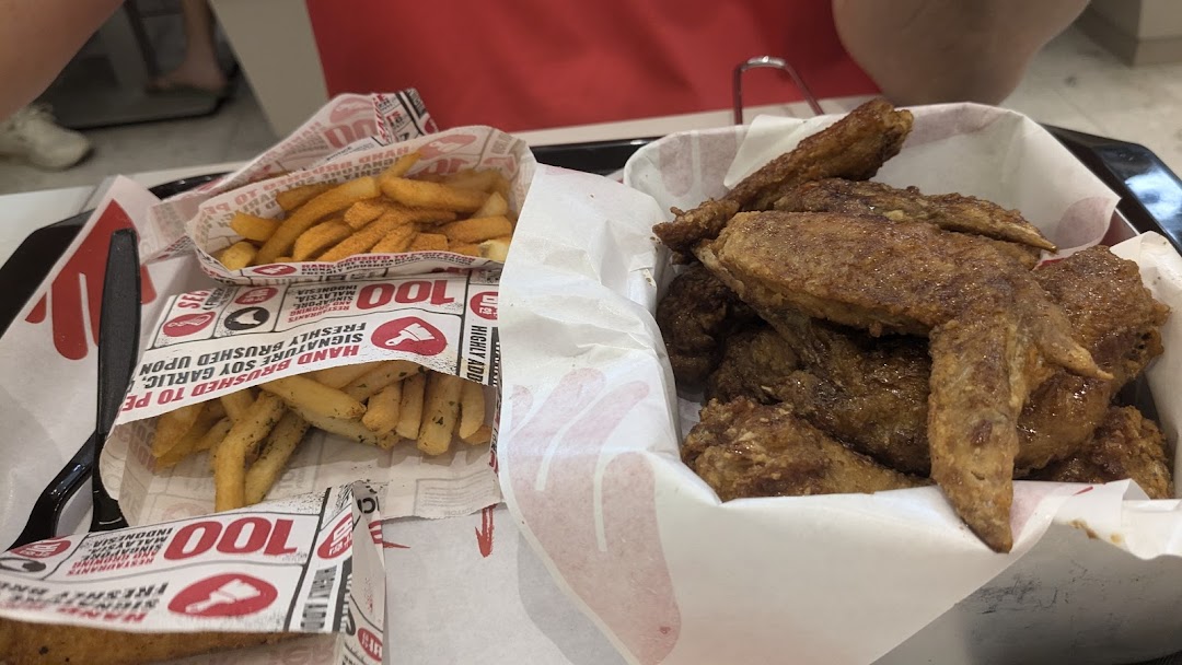 A tray featuring crispy chicken wings and seasoned fries from 4Fingers Crispy Chicken.