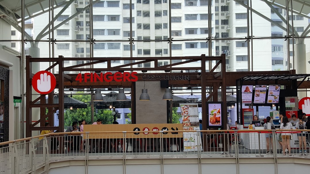 A view of the 4Fingers Crispy Chicken shop front with customers and menu displays.