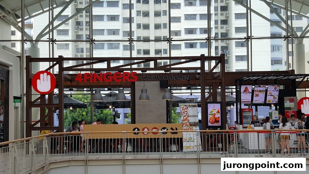 A view of the 4Fingers Crispy Chicken shop front with customers and menu displays.