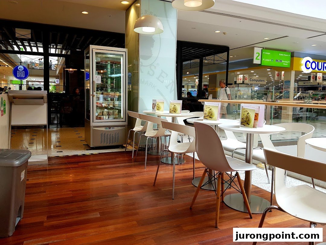 The entrance of Andersens of Denmark cafe with a display fridge and outdoor seating area.