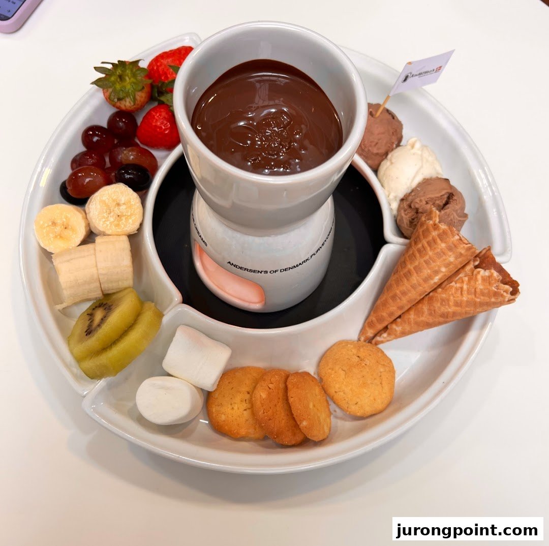 A delightful chocolate fondue set with fresh fruits, marshmallows, cookies, and ice cream.