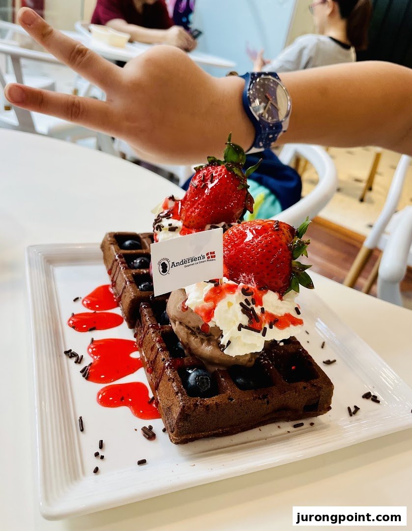 A delicious chocolate waffle topped with strawberries, blueberries, ice cream, and whipped cream from Andersens of Denmark.