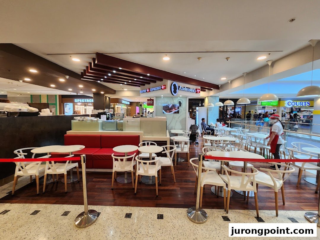 The interior of Andersens of Denmark cafe, featuring seating, a counter, and a view of the mall.