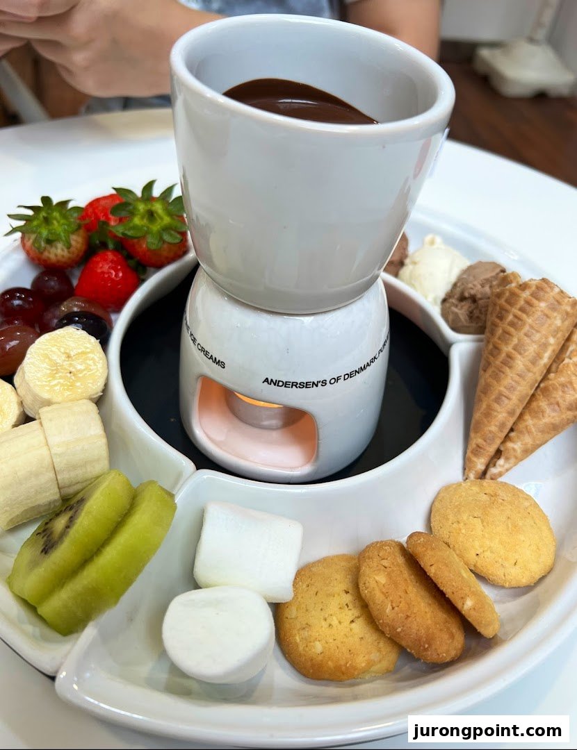 A delightful chocolate fondue set with fresh fruits, marshmallows, cookies, ice cream, and waffle cones.