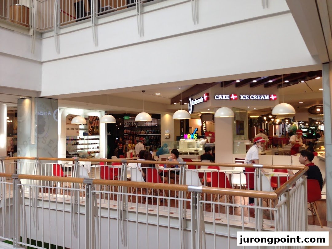 A vibrant interior view of Andersens of Denmark, featuring its cake and ice cream counter and a lively seating area.