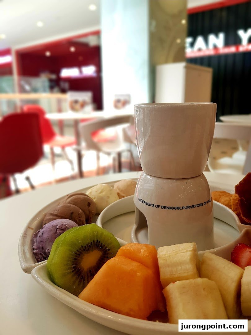 A delightful dessert platter featuring ice cream, fresh fruit, and a fondue pot from Andersens of Denmark.