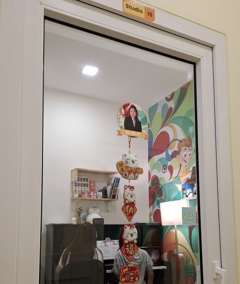 A bright music studio at Aureus Academy with students learning piano, seen through a glass door.