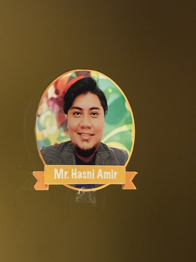 A circular photo of Mr. Hasni Amir, likely an instructor at Aureus Academy.