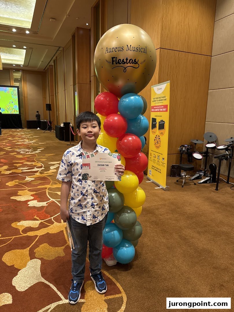 A child proudly holds a certificate at an Aureus Musical Fiestas event.