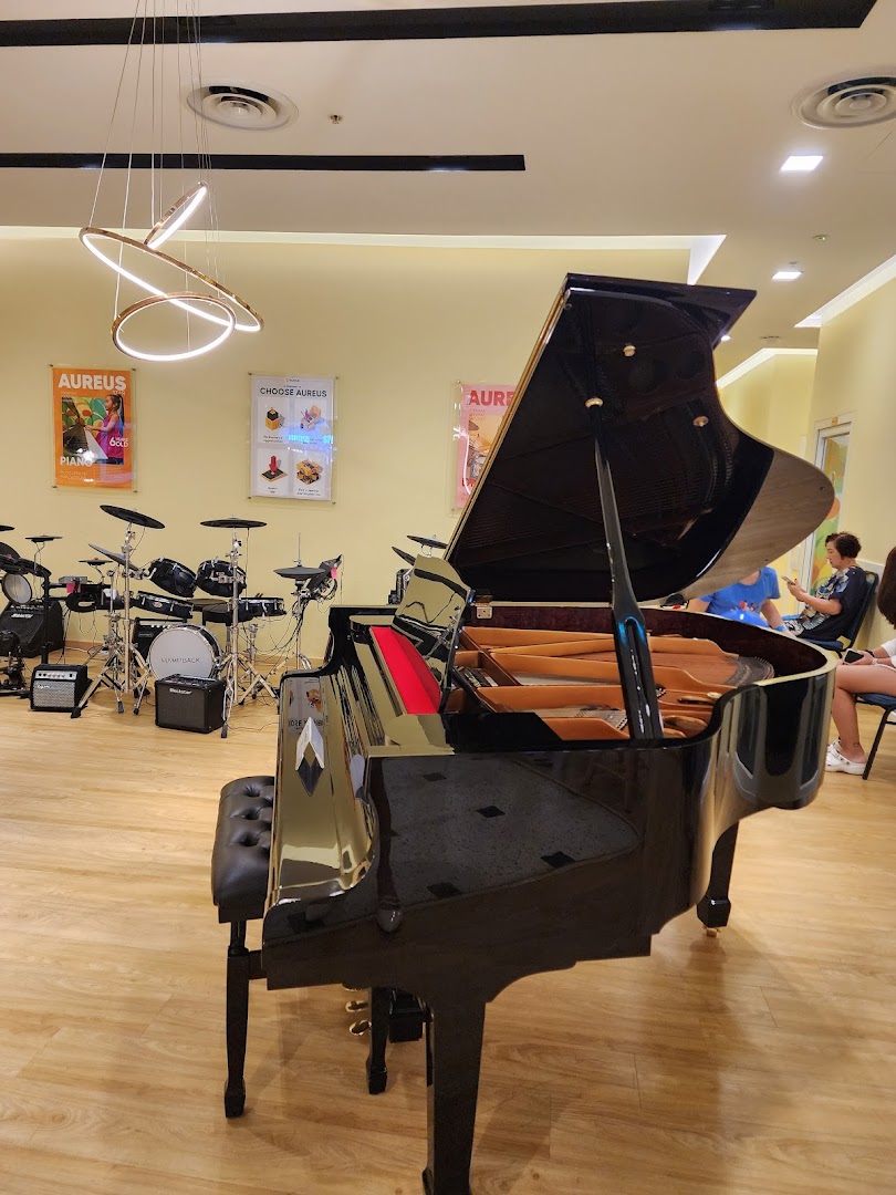 A grand piano and drum set in the bright, inviting interior of Aureus Academy.