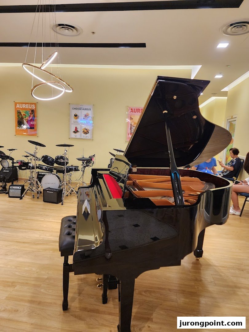 A grand piano and drum set in the bright, inviting interior of Aureus Academy.