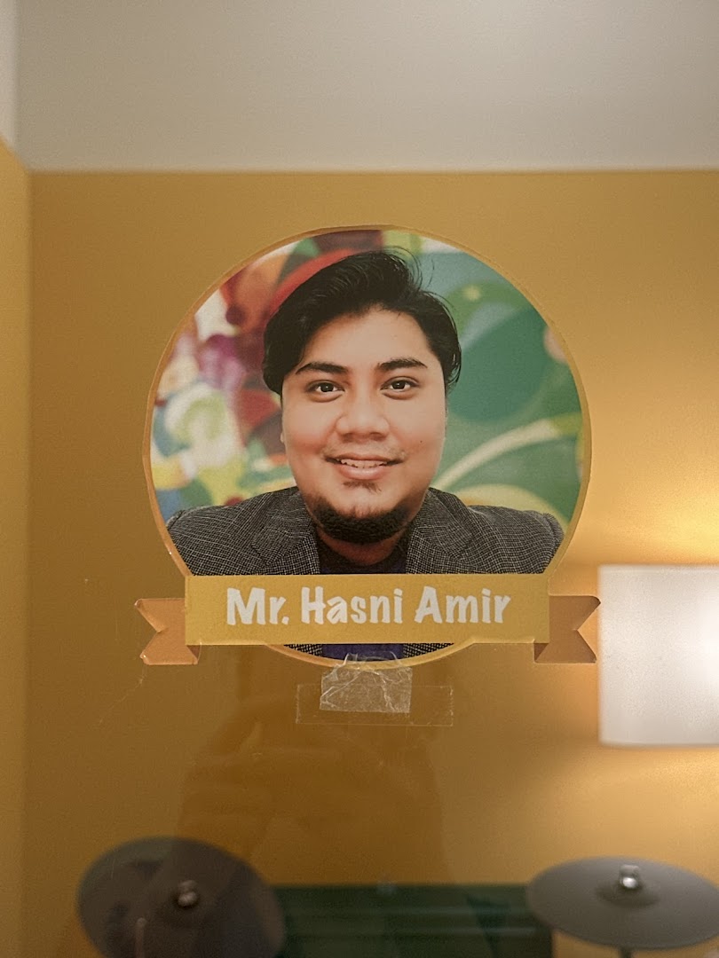 A portrait of Mr. Hasni Amir, likely an instructor, displayed inside Aureus Academy.