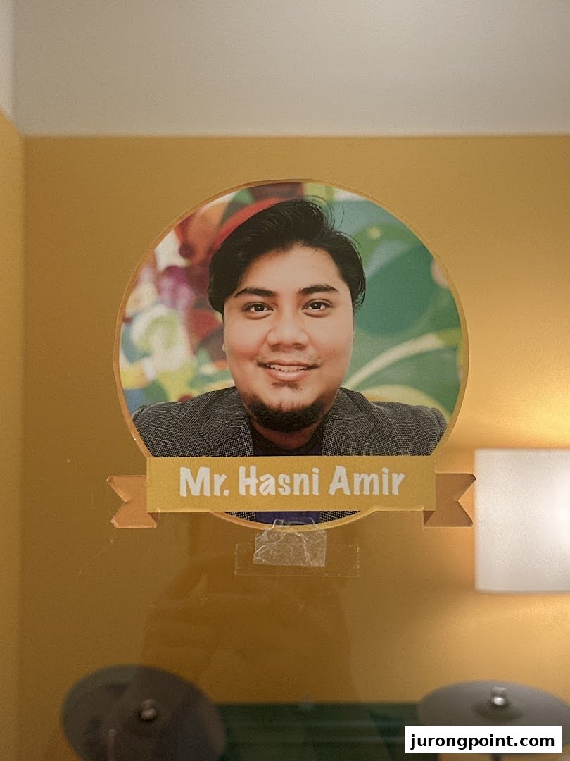 A portrait of Mr. Hasni Amir, likely an instructor, displayed inside Aureus Academy.