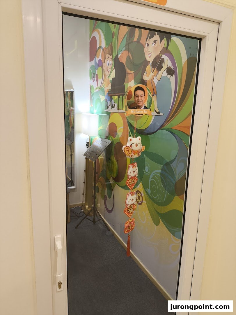 A glass door reveals a vibrant music academy room with colorful wall art and musical instruments.