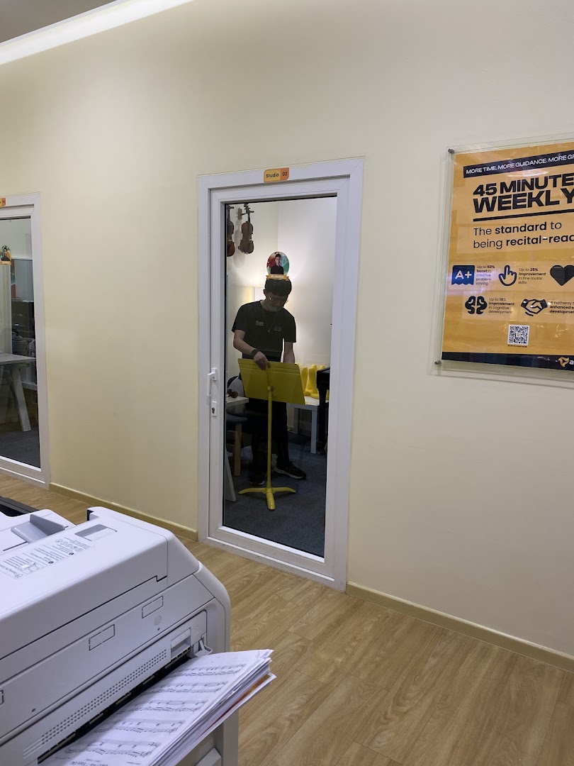 Interior view of Aureus Academy, showing a music studio door and a promotional poster.
