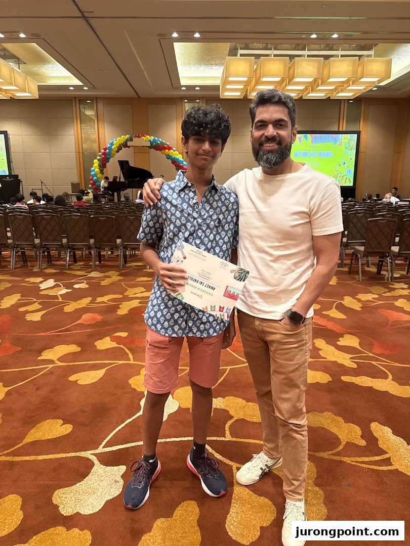 A student and adult proudly display a certificate at an Aureus Academy music event.