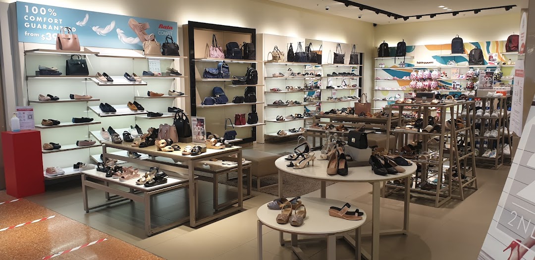 An interior view of a Bata store showcasing a wide selection of shoes and handbags on display.
