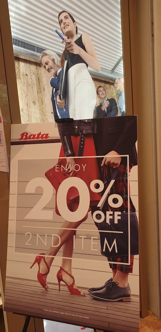 A Bata promotional standee advertising 'Enjoy 20% Off 2nd Item' with models wearing shoes.